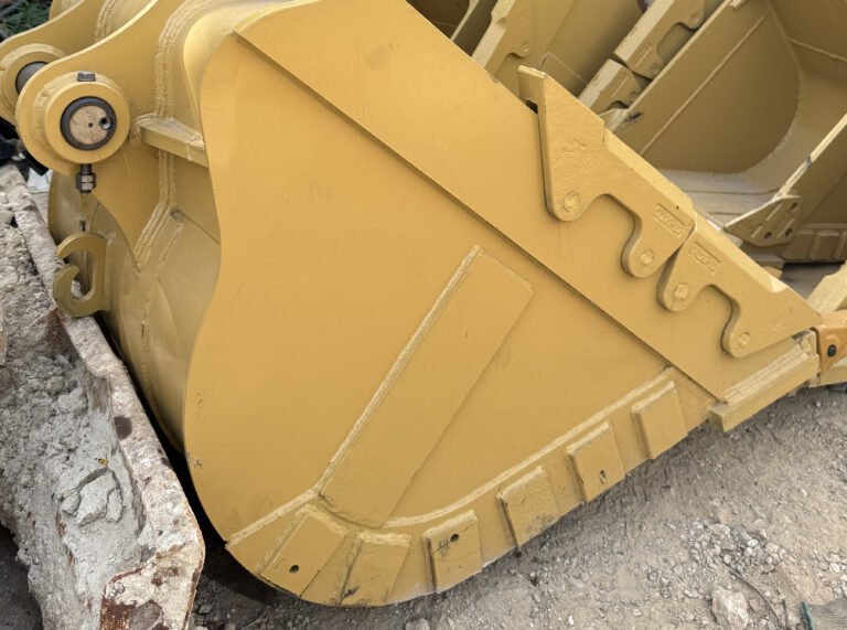 Yellow bucket detail showing a circular connection feature, curved body, raised strips and projecting features along the edge.