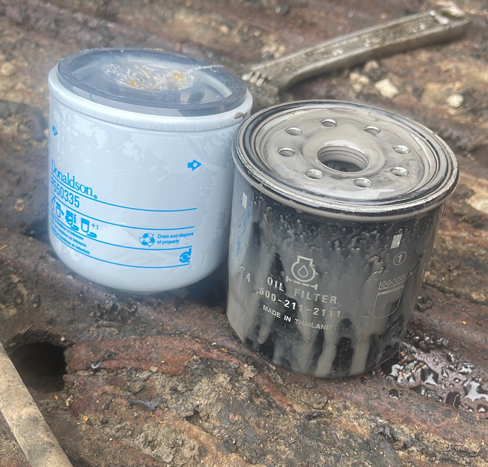 Two differently finished spin-on filter-like components shown side by side.