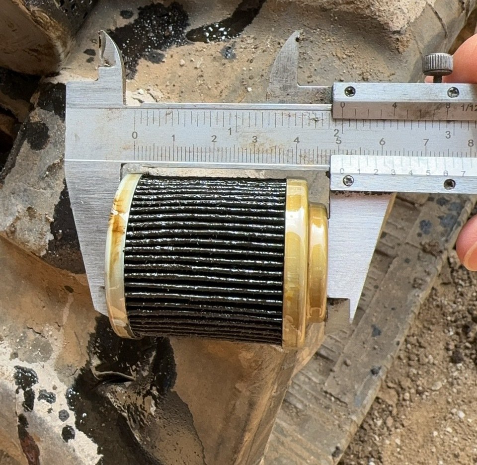 A small pleated element between caliper jaws on a work surface.