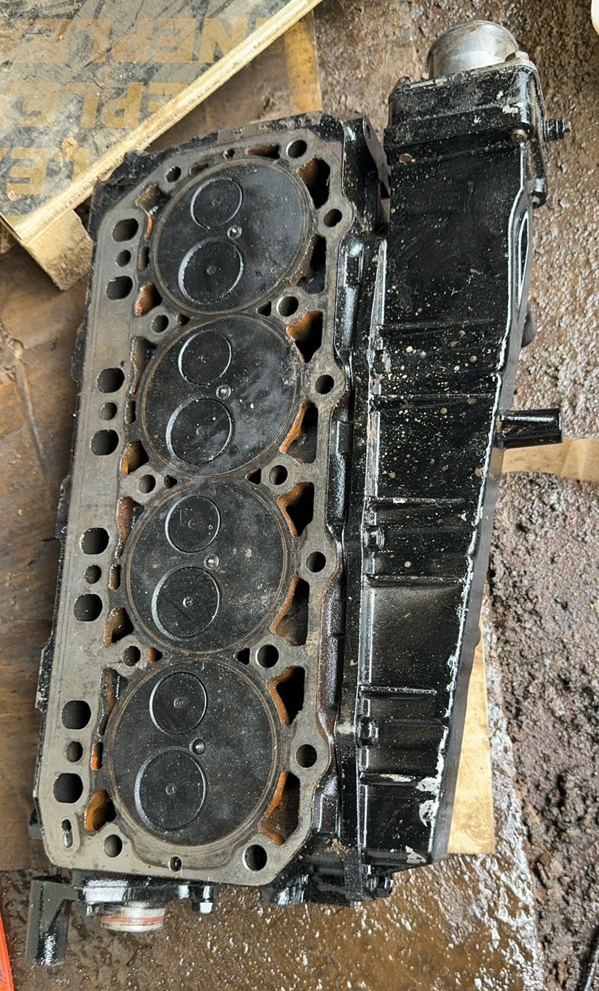 A detached engine-head-like face with repeated circular valve areas beside a dark cover.