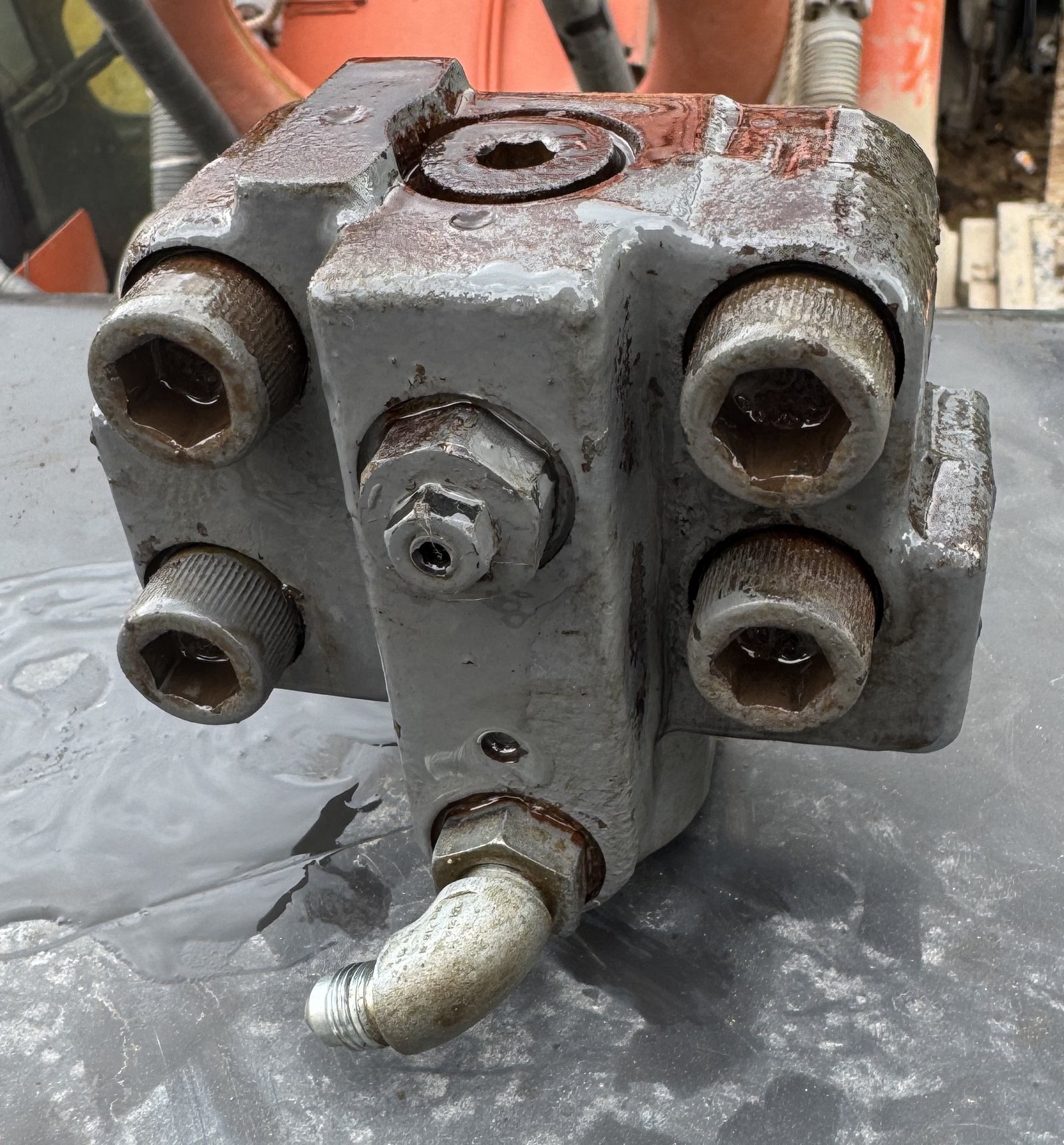 A close valve-block-like face with several large hexagonal plugs and openings.